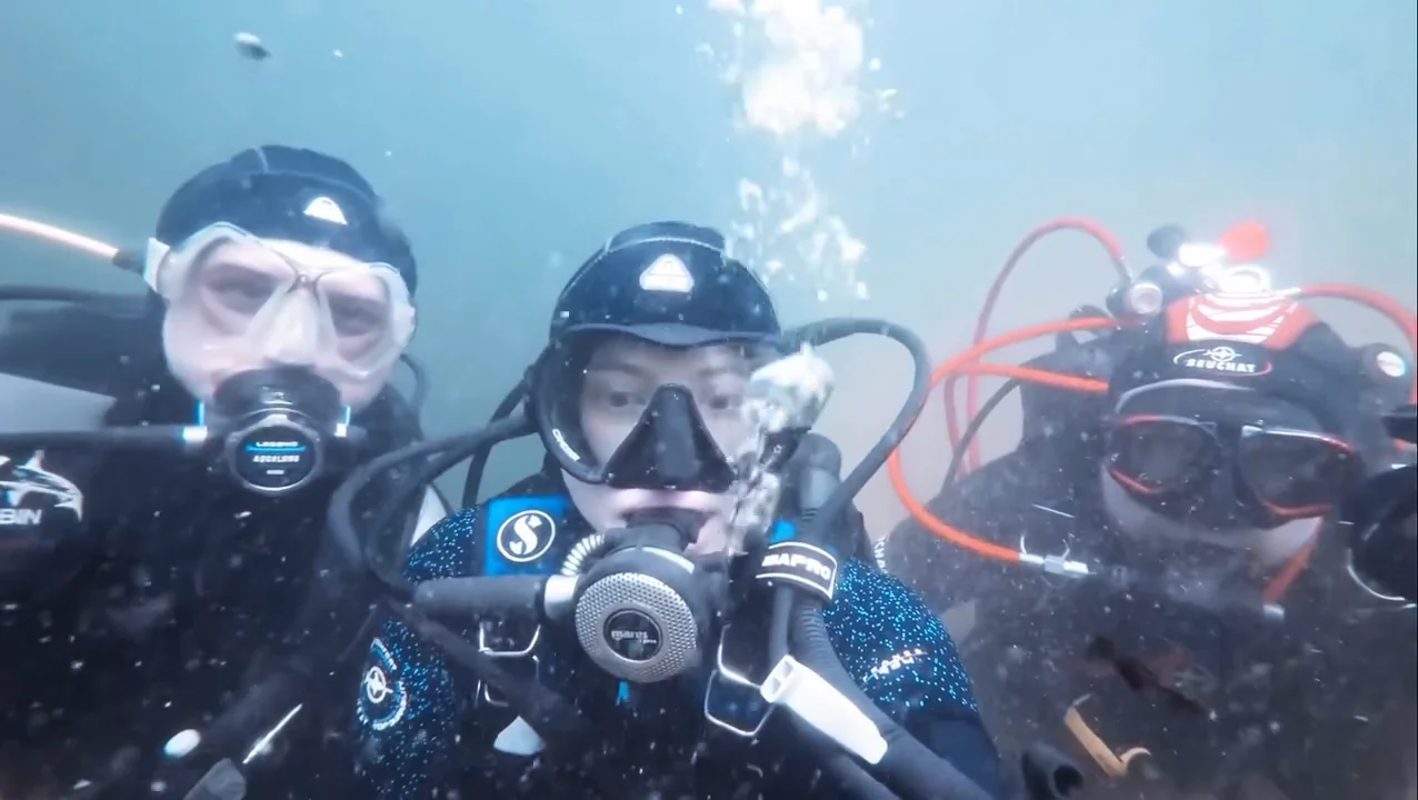 Drei Taucher des TSC Shark Mannheim machen beim Antauchen 2026 ein Gruppenfoto unter Wasser