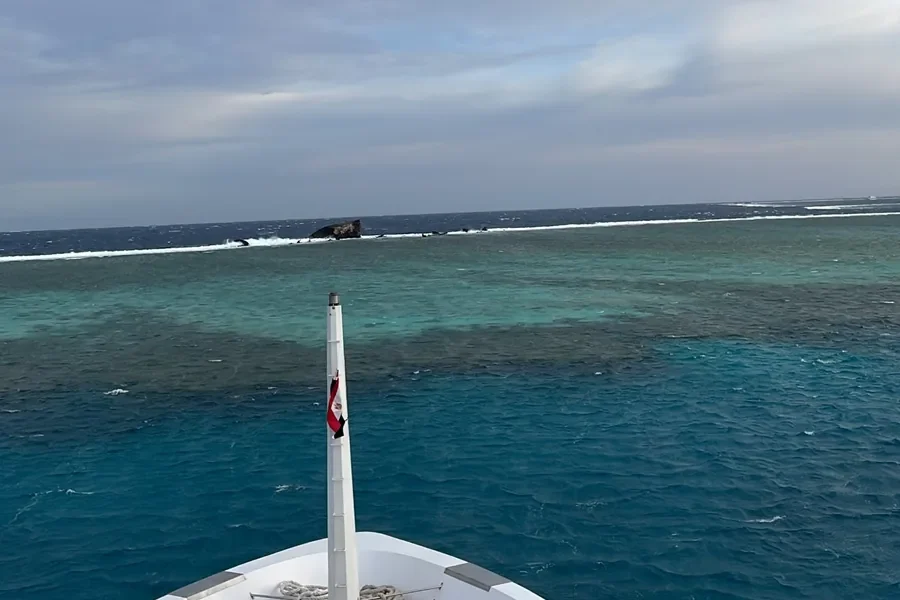Blick vom Bug der Seawolf Steel auf ein Riff mit Brandung bei windigem Wetter
